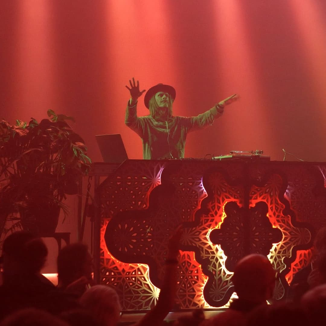 Scott Nice performing behind ornate stage design in red light